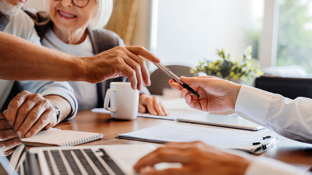 Starsza osoba podpisująca dokumenty w kancelarii prawnej na Greenpoincie.