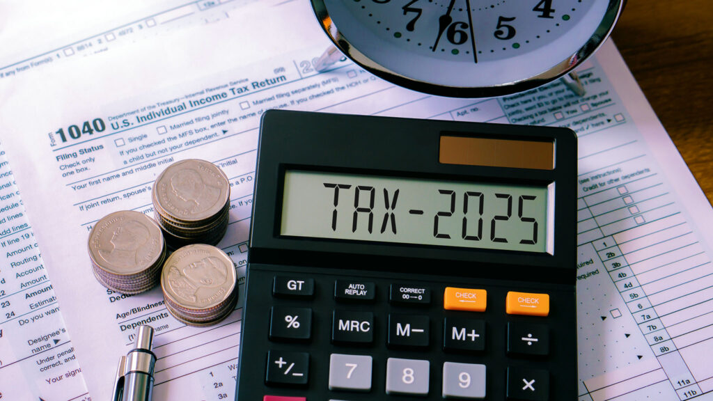 Calculator and tax documents on the desk of an Imperium Group of NY accountant.