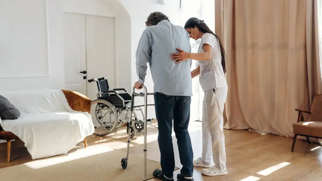 Caregiver assisting a senior with a walker at a nursing home