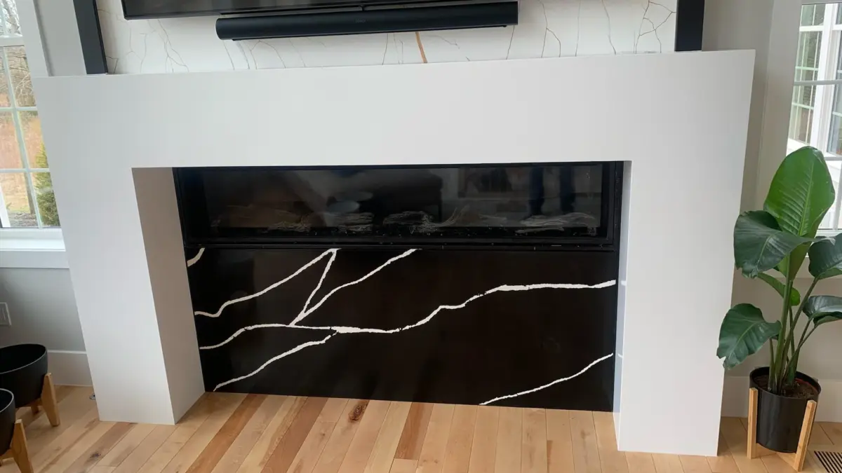 Jasna obudowa kominka z czarnym kamieniem z białym użyleniem