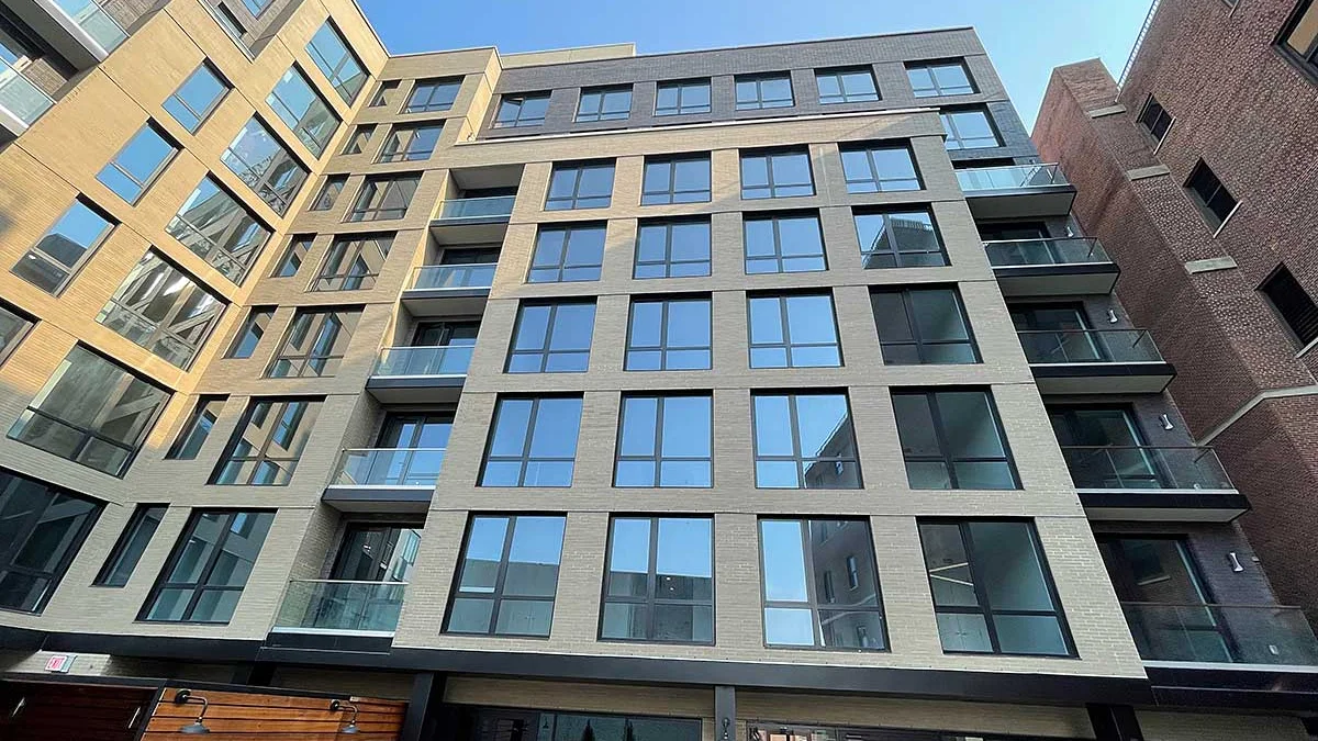 New multi-story multifamily building in New York with large windows and balconies