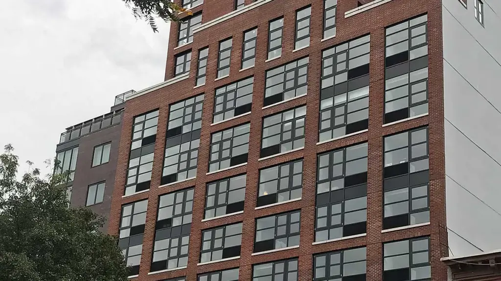Brick multifamily building in New York with rows of new windows